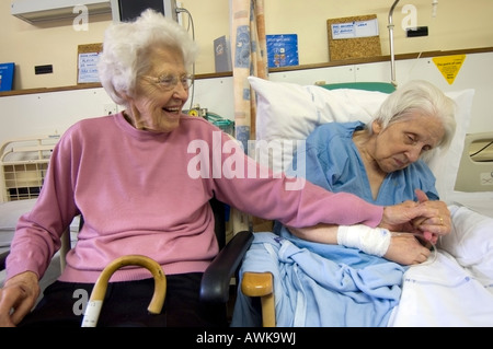 Sisterly love as an 89 year old lady visits her frail 92 year old sister at Leicester General Hospital Stock Photo