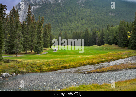 A field for a golf and rather shallow mountain small river in mountains Stock Photo