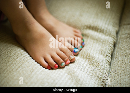 Little girl aged four years hand paints her own toenails with felt tip pens Stock Photo
