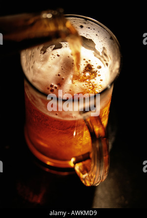 Beer being poured into mug, high angle view, close-up Stock Photo