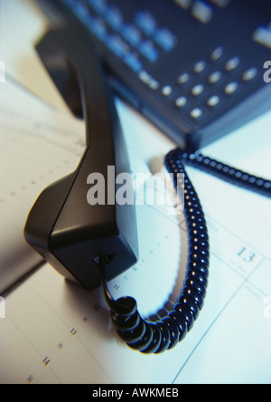 Phone off hook, on open agenda, close-up Stock Photo