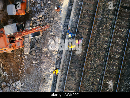 Men wearing hard hats, standing on rails, elevated view Stock Photo