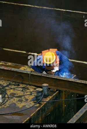 Welder wearing protective mask on construction site Stock Photo