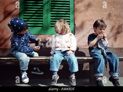 Children sitting on bench Stock Photo