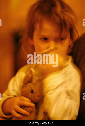 Girl hugging stuffed rabbit, portrait, blurred Stock Photo