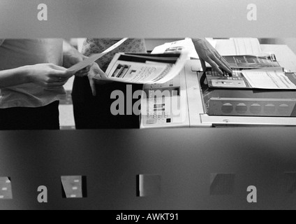 People using photocopier, mid section, b&w Stock Photo