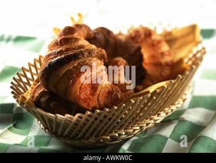 Croissants in basket on green checked tablecloth, close-up Stock Photo