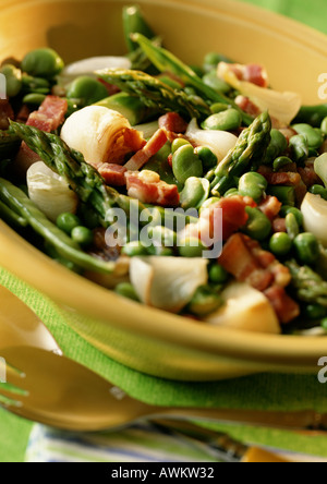 Dish of asparagus, peas and bacon in bowl, close-up Stock Photo