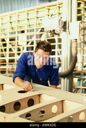 Man in coveralls behind woodwork, looking into camera, head and shoulders Stock Photo