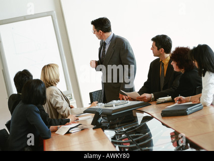Businessman giving presentation, colleagues watching Stock Photo