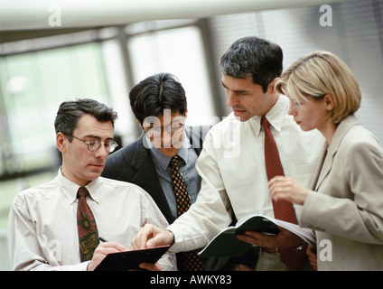 Four business people examining document Stock Photo