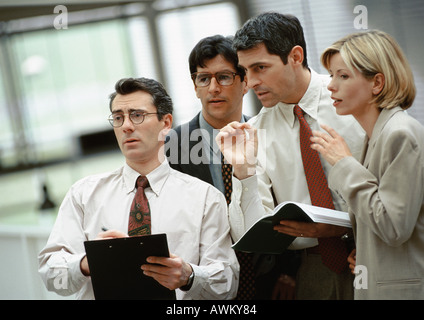 Four investors standing side by side, talking Stock Photo