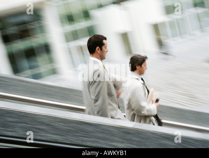 Two businessmen walking down stairs, blurred Stock Photo