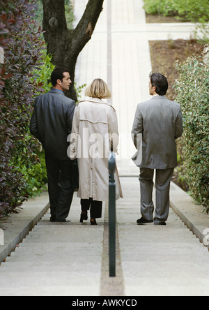 Three business people going down stairs, rear view Stock Photo
