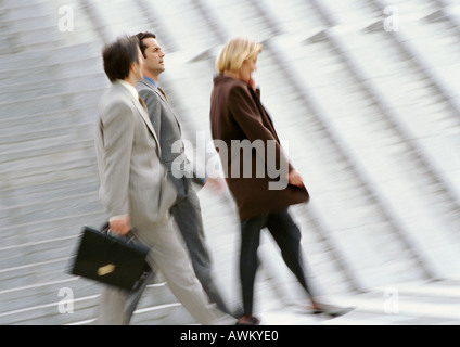 Three business people walking, blurred Stock Photo