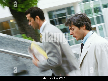Two businessmen walking up stairs, upper section,  blurred Stock Photo
