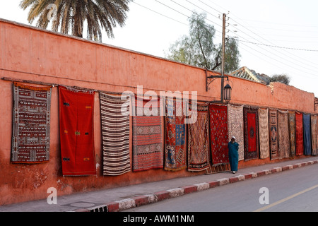 Colourful Berber rugs draped along a long wall in the historic Medina quarter, Marrakesh, Morocco, Africa