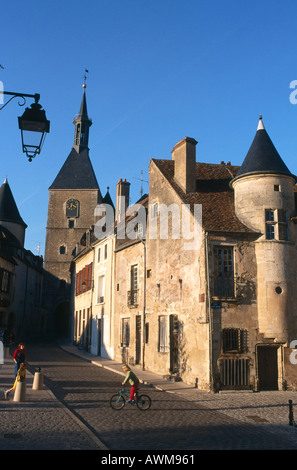 Girl cycling in street, old part of town, Avallon, Burgundy, France Stock Photo