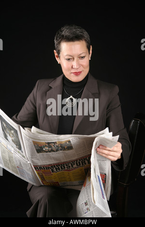 Woman reading newspaper Stock Photo