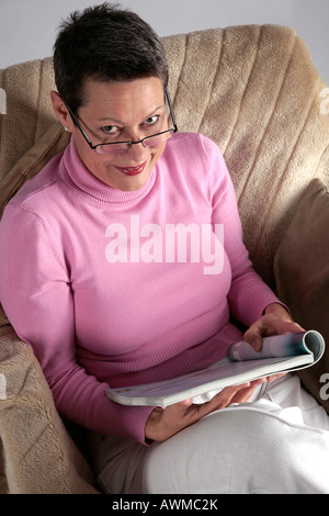 Woman sitting comfortably on armchair Stock Photo