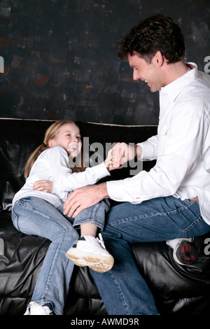 Father and daughter tussling on the couch Stock Photo