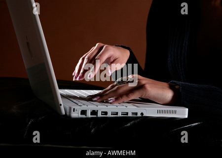 Young woman typing on laptop Stock Photo
