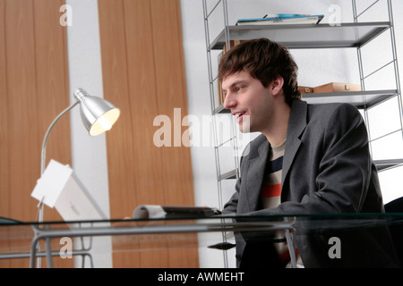 Young man working happily at his desk Stock Photo