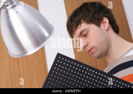 Young man looking though a file, focused Stock Photo