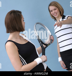 Two girls dressed in sportswear holding a tennis racket Stock Photo