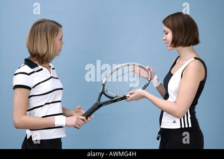 Two girls dressed in sportswear with a tennis racket Stock Photo