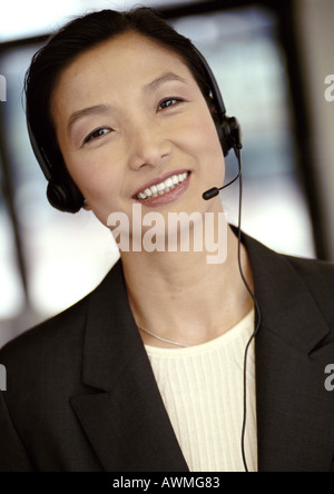 Businesswoman wearing headset, smiling at camera, portrait Stock Photo