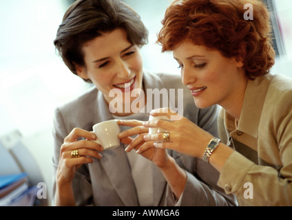 Two businesswomen side by side, holding coffee cups Stock Photo