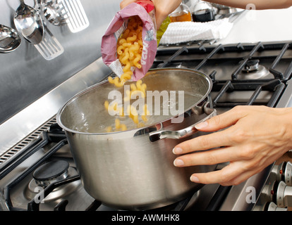 WOMAN IN KITCHEN COOKING PASTA Stock Photo