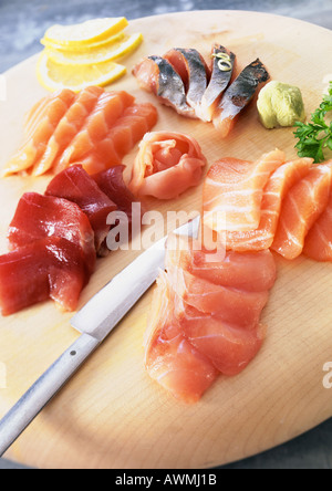 Sashimi with wasabi and lemon slices on wooden board Stock Photo