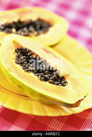 Two papaya halves on yellow plate, close-up Stock Photo
