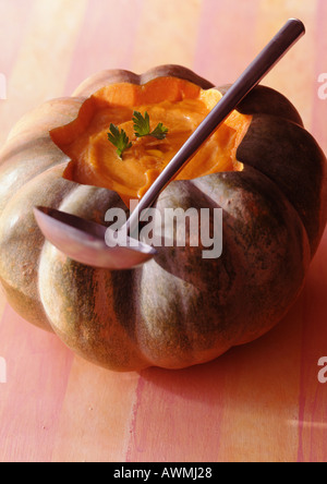 Pumpkin soup in pumpkin shell with ladle, close-up Stock Photo