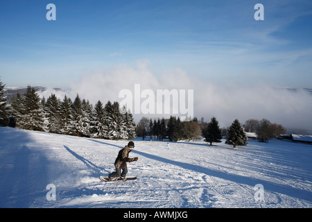 Snowboarder on a ski-run, Mt. Kreuzberg near Bischofsheim, Rhoen Mountains, Lower Franconia, Bavaria, Germany, Europe Stock Photo
