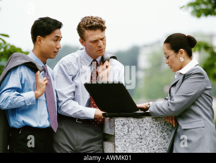 Business associates together looking at laptop computer Stock Photo