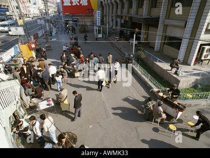 China, Xinjiang, Urumqi, street vendors,customers, pedestrians, high angle view Stock Photo