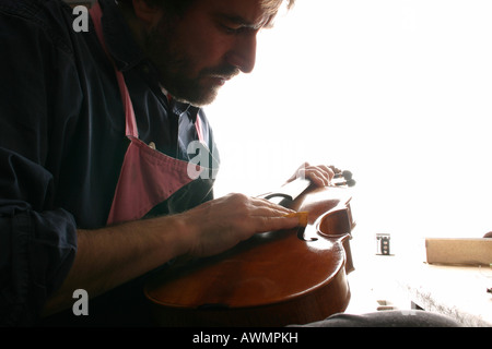Violin-maker (luthier) repairing a violin Stock Photo