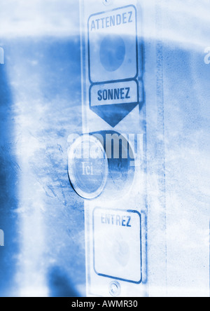 Security entrance button, with "wait, ring, here, enter" text in French, close-up Stock Photo