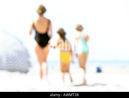 Women and children standing on the beach, blurred