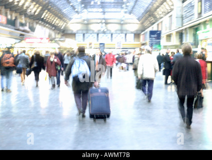 People walking in train station, blurred Stock Photo