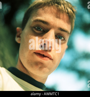 Young man outside, looking at camera, close up, portrait, low angle view Stock Photo