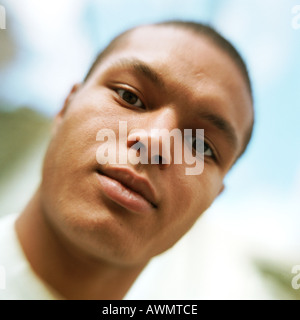 Young man looking at camera, low angle view, close-up, portrait. Stock Photo