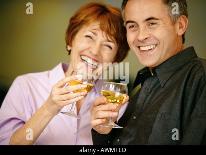 Man and woman smiling and holding up wine glasses, close up Stock Photo