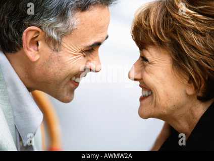 Mature man and woman looking at each other smiling, close up Stock Photo