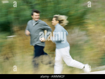 Man and woman jogging together in field, blurred Stock Photo