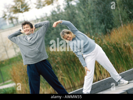Man and woman stretching together outside Stock Photo