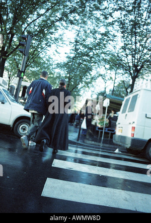 Young couple walking on pedestrian crossing, rear view Stock Photo